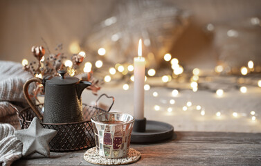 Cozy winter background with details of home decor on a blurred background with lights copy space.
