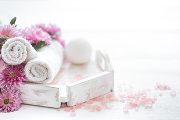 Spa composition with body care products and pink flowers copy space.