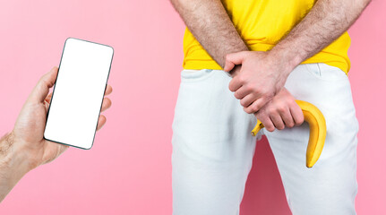 Potency and men's health. A man in white jeans, legs spread, covers his genitals with one hand, and...