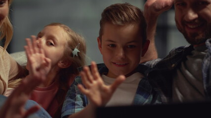 Happy parents and kids having video call on computer. Family spending time home