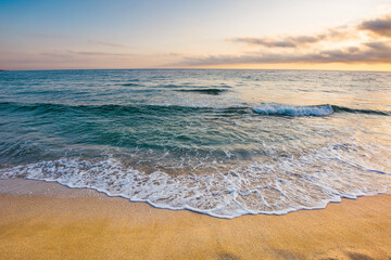 sunrise at the sea. beautiful summer landscape on the sandy beach. green waves rush on the shore in golden light