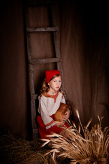 Obraz premium little girl in a light linen shirt and a red scarf in a rustic style