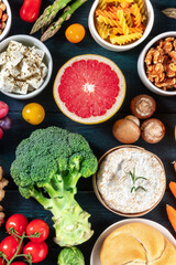 Vegetarian diet, overhead shot. Fruit and vegetables, cheese, mushrooms, nuts, pasta, bread, a variety of foods on a dark blue wooden background