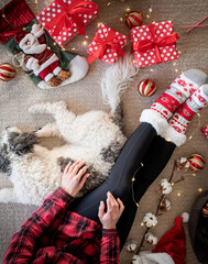 Top view of woman in funny socks celebrating Christmas with her dog
