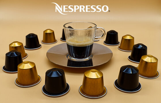 Bologna / Italy - November 10, 2020: Transparent Nespresso glass of coffee and capsules. Nespresso is a brand selling coffee and coffee products all over the world