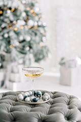 Happy New Year 2021.Christmas and New Year holidays minimal background, winter season. A glass of champagne against a background of bokeh lights. Soft selective focus.