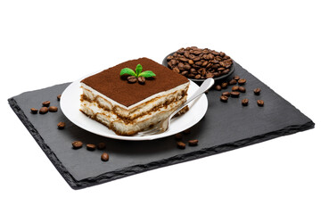 Traditional Italian Tiramisu square dessert portion on ceramic plate and coffee beans on stone serving cutting board isolated on white