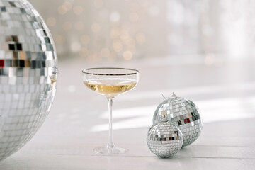 Happy New Year 2021.Christmas and New Year holidays minimal background, winter season. A glass of champagne against a background of bokeh lights. Soft selective focus.
