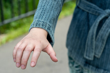 A close-up of a hand outstretched forward with the intention of opening the door. Hand outstretched in a gesture to open the handle.