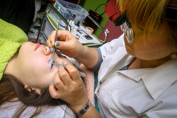 Eyelash extension procedure, woman eye with Long eyelashes