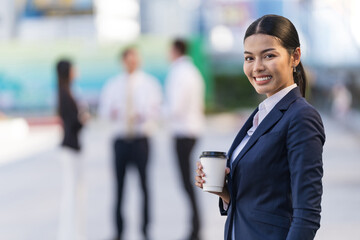 Fototapeta na wymiar Portrait of smiling business woman holding a coffee cup