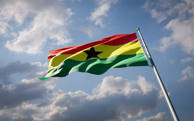 Ghana national flag waving at sky background close-up.