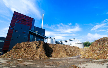 bio power plant with storage of wooden fuel (biomass) against blue sky