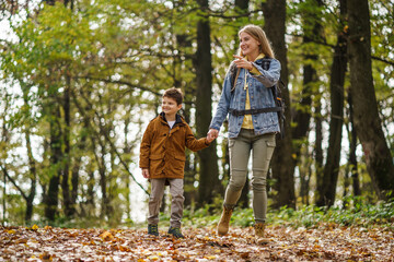 Fototapeta premium Happy mother and son are hiking in forest.