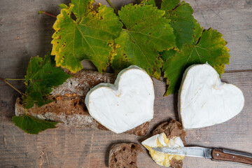 French Neufchatel cheese shaped heart on autumn leaves