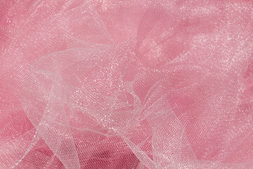 Pink tulle fabric texture top view. Coral background. Fashion color trends feminine tutu skirt flat lay, female blog backdrop for text signs desidgn. Girly abstract wallpaper, textile surface.