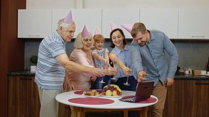 Happy multigenerational family members making birthday anniversary surprise sending congratulations online with laptop during coronavirus, covid-19 quarantine lockdown. Together. Families concept