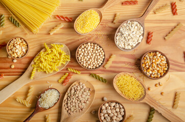 Flat lay Food background made of legumes cereals pasta and grains in wooden spoons on kitchen table