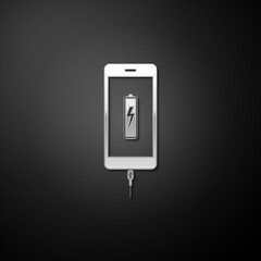 Silver Smartphone battery charge icon isolated on black background. Phone with a low battery charge and with USB connection. Long shadow style. Vector.