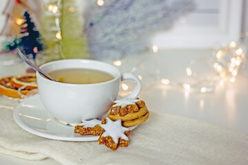 Homemade christmas star cookies on wooden tray beside  tea cup