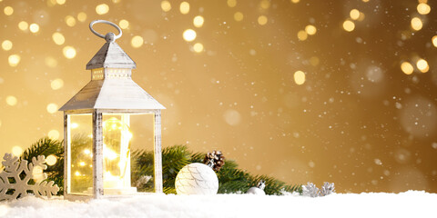 Burning lantern with christmas decoration in the snow