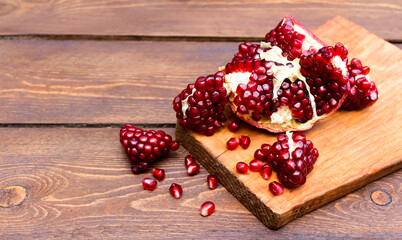 Pomegranate fruit on a wooden background. Vitamins for health during a pandemic. Protection from coronavirus.