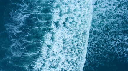 Beautiful marine background. Aerial top view of waves, foam, water, ocean.