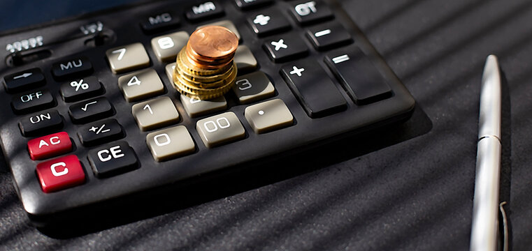 stack of coins on calculator near tax sign,concept for business and tax time.