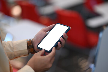 Close up view of businesswoman is holding smartphone with blank screen. Blank screen for graphics display montage.