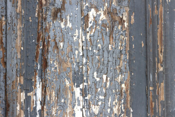 The surface of old wooden boards with peeling and weathered paint.