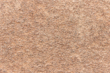 The surface of a rough uneven wall, plastered with fine marble chips.