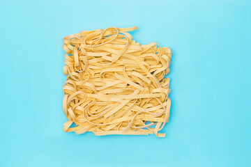 An overhead photo of egg noodles on blue background. - 392811809