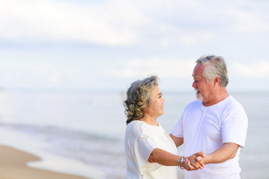 Asian Senior Love Couple Travel Relaxing On The Beach. Retirement And Recreation On Summer Holiday.