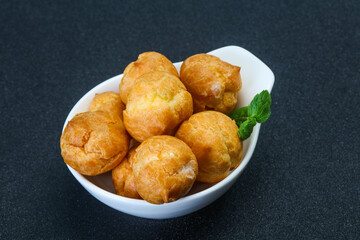 Sweet tasty profiteroles heap in the bowl