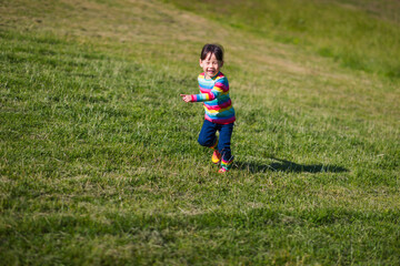 young girl running in the summer garden in the morning