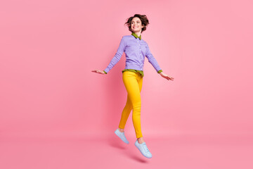 Fototapeta na wymiar Full size photo of cheerful lady jump up good mood wear jumper yellow pants sneakers isolated pink color background