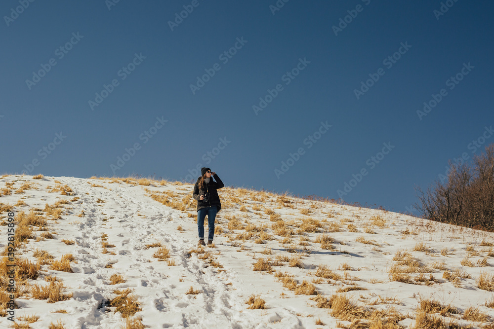 Wall mural the pretty girl looking on the beautiful view at the mountain in the sunny day. blue sky with copy s