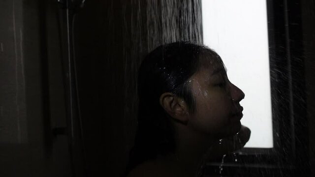 Asian woman showering in hotel bathroom use rain shower in slow motion 500pfs video