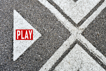 The word play written on asphalt road with direction arrows. Start to play sports game, music or multimedia movie.