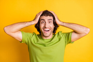 Photo of funky crazy guy hands head open mouth look camera wear green t-shirt isolated yellow color background
