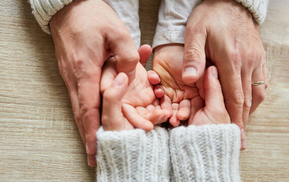 Seniors hands hold the hands of a child