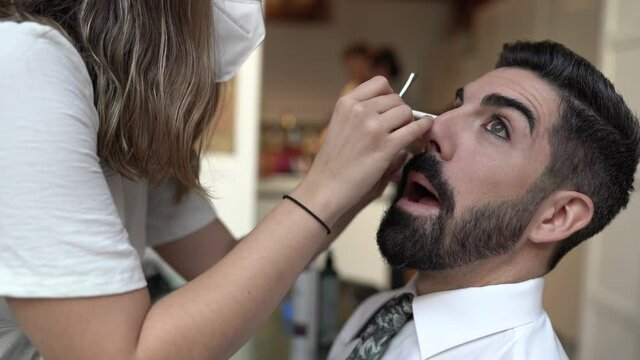 Make-up artist wearing protective mask, applying make-up for wedding