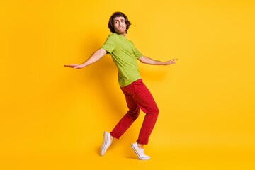 Full length body size photo of man going tiptoes looking nervous afraid fear burglar biting lip isolated on vivid yellow color background