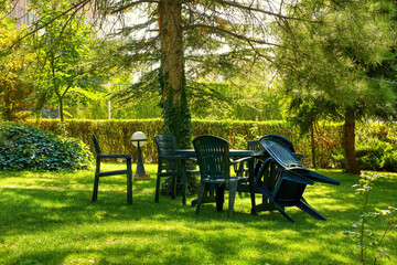 Green plastic garden furniture with chairs and table on green grass