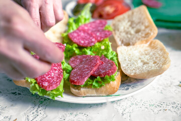 The woman is making sandwiches. Homemade sandwiches