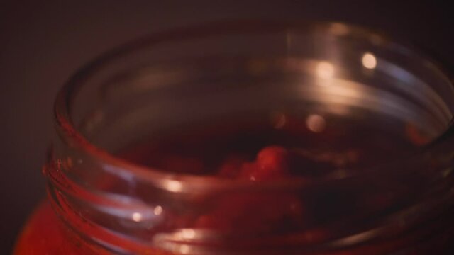 Opening glass jar of tomato sauce close up. Ingredient for meal like tomato pasta, spaghetti, traditional pizza. Vegetarian mediterranean recipe ingredient.
