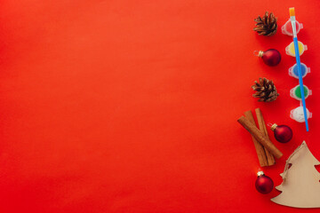 red background DIY or handmade with children new year or christmas mood decoration. paint and brush, cones, christmas tree, cinnamon. Template mockup greeting card text design with copy space