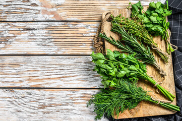 Assortment of fresh herbs coriander, rosemary, thyme, dill, parsley. A bunch of fresh condiments. White background. Top view. Copy space