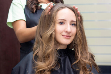 Fototapeta premium Womens hairdresser, beauty salon. Close up of a hairdresser doing a hairstyle.