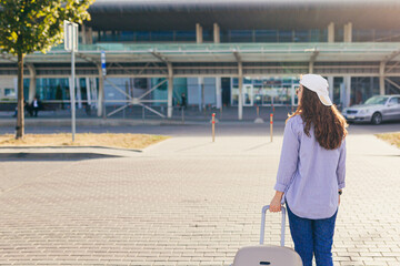 A young beautiful girl student leaves the airport in a new city, and waits for a taxi